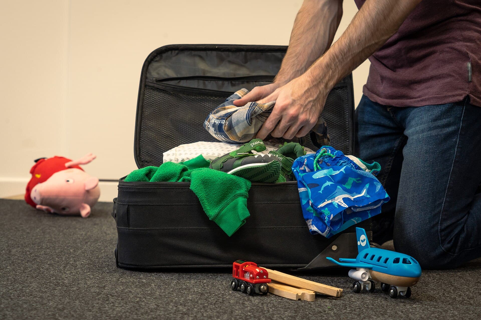 Clothes, shoes and travel items laid out while packing for a family holiday