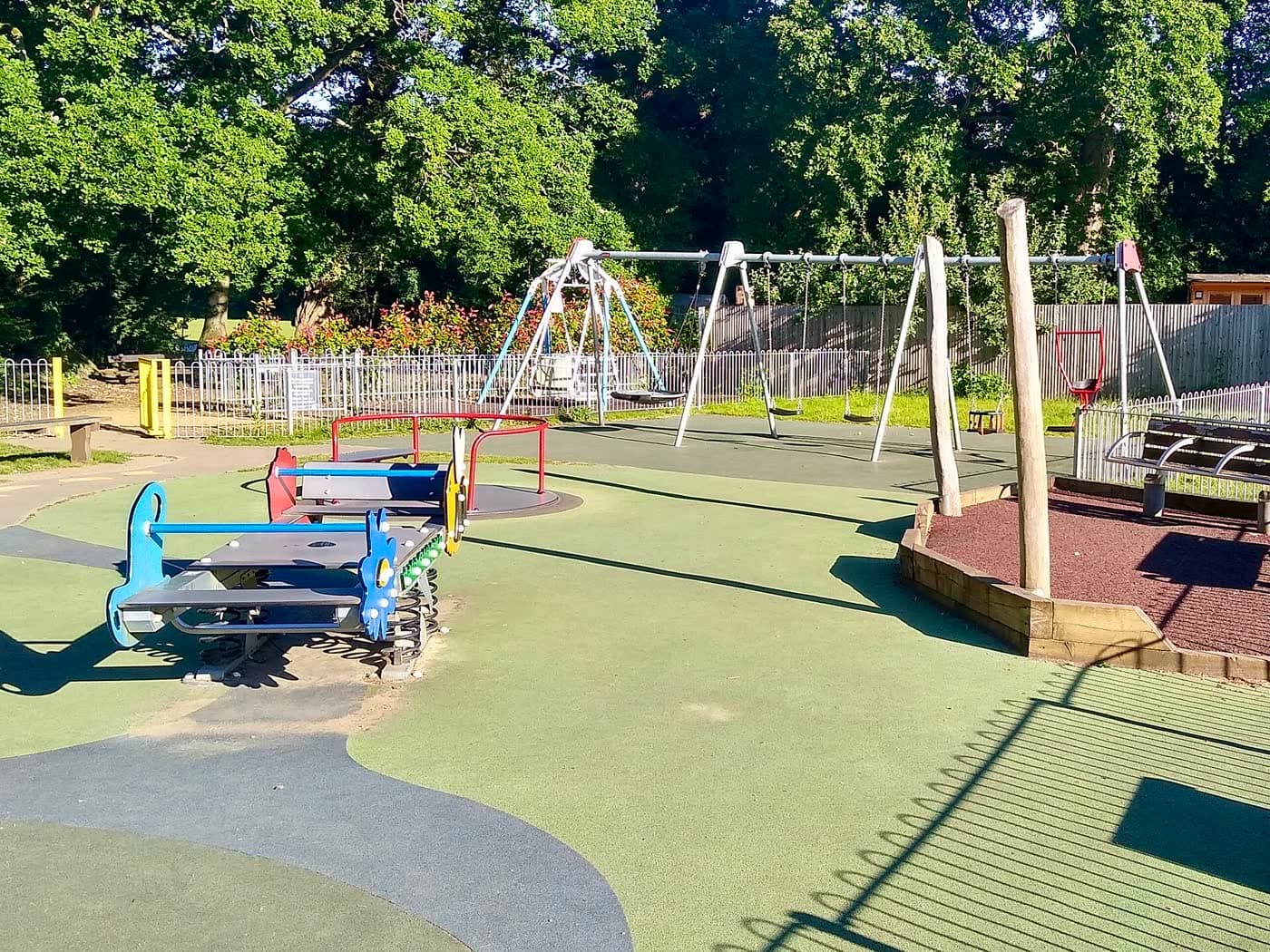 A children's playground with climbing frames and a slide in a park
